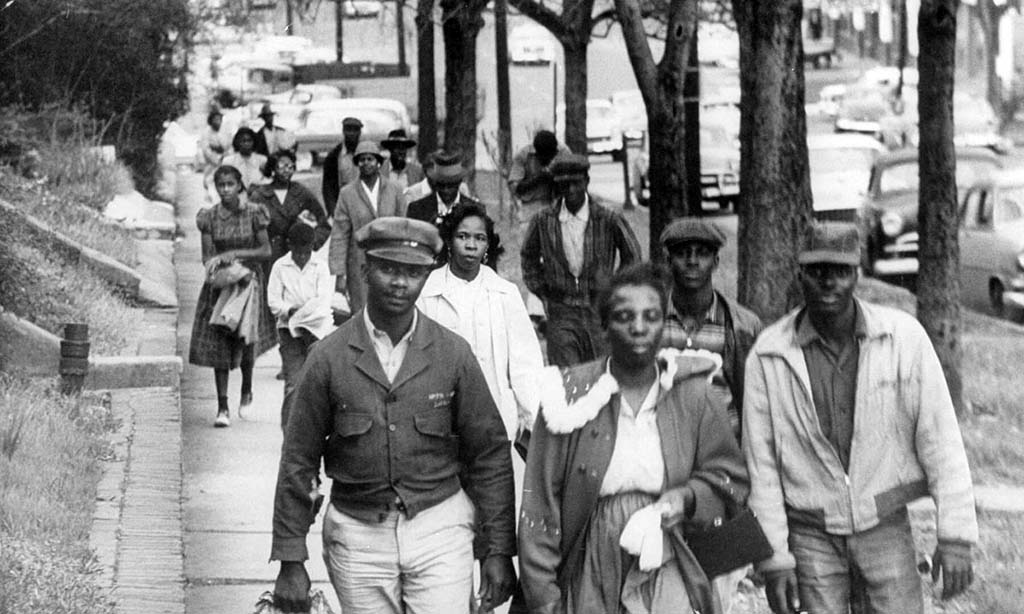 black and white photo of Black people walking on a sidewalk during the Montgomery Bus Boycott