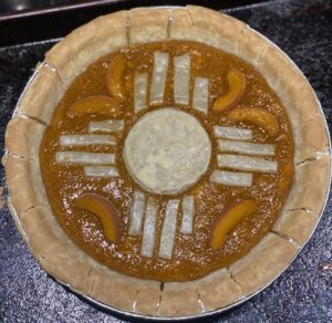 Apricot pie baked stylized with the Zia symbol on the top